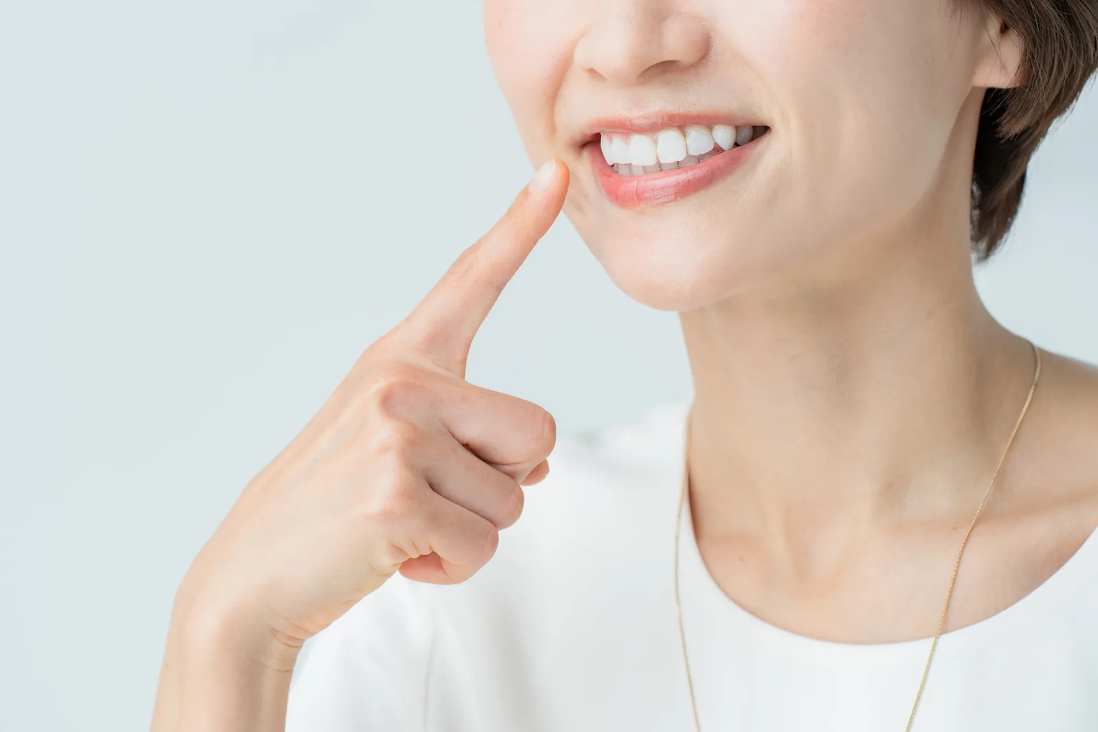 白くなった歯を指し示す女性